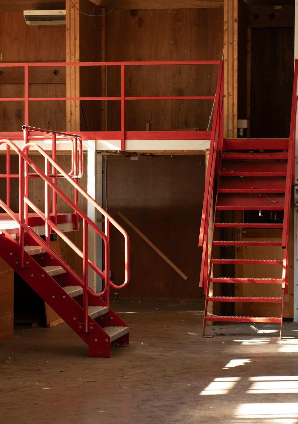 a red stair case next to a set of stairs
