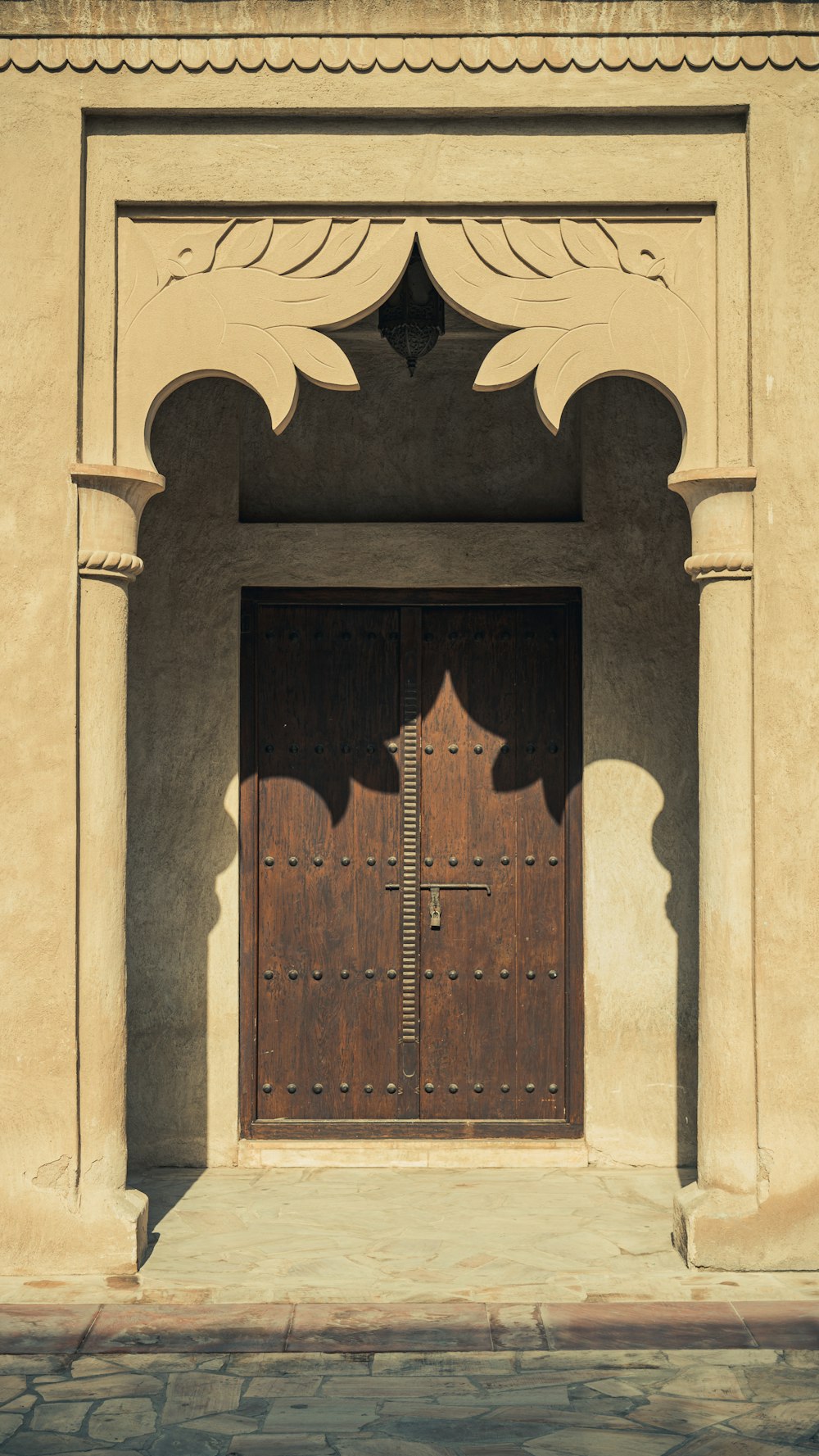 a building with two wooden doors and a clock
