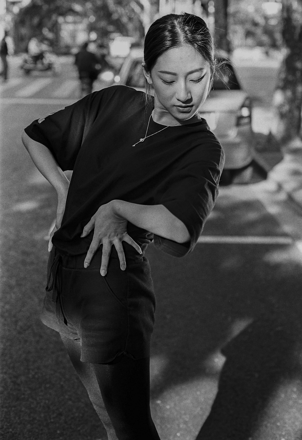 a woman standing on a street corner with her hand on her hip