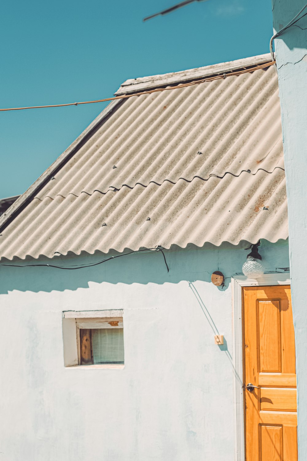 a white building with a yellow door and a brown door