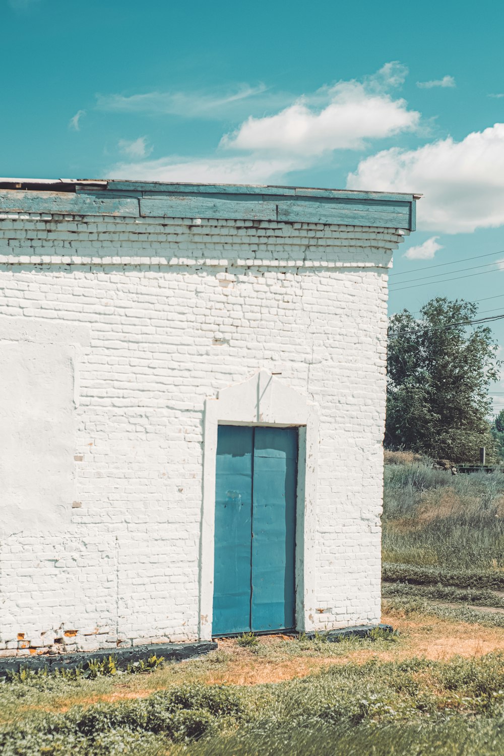 a white brick building with a blue door