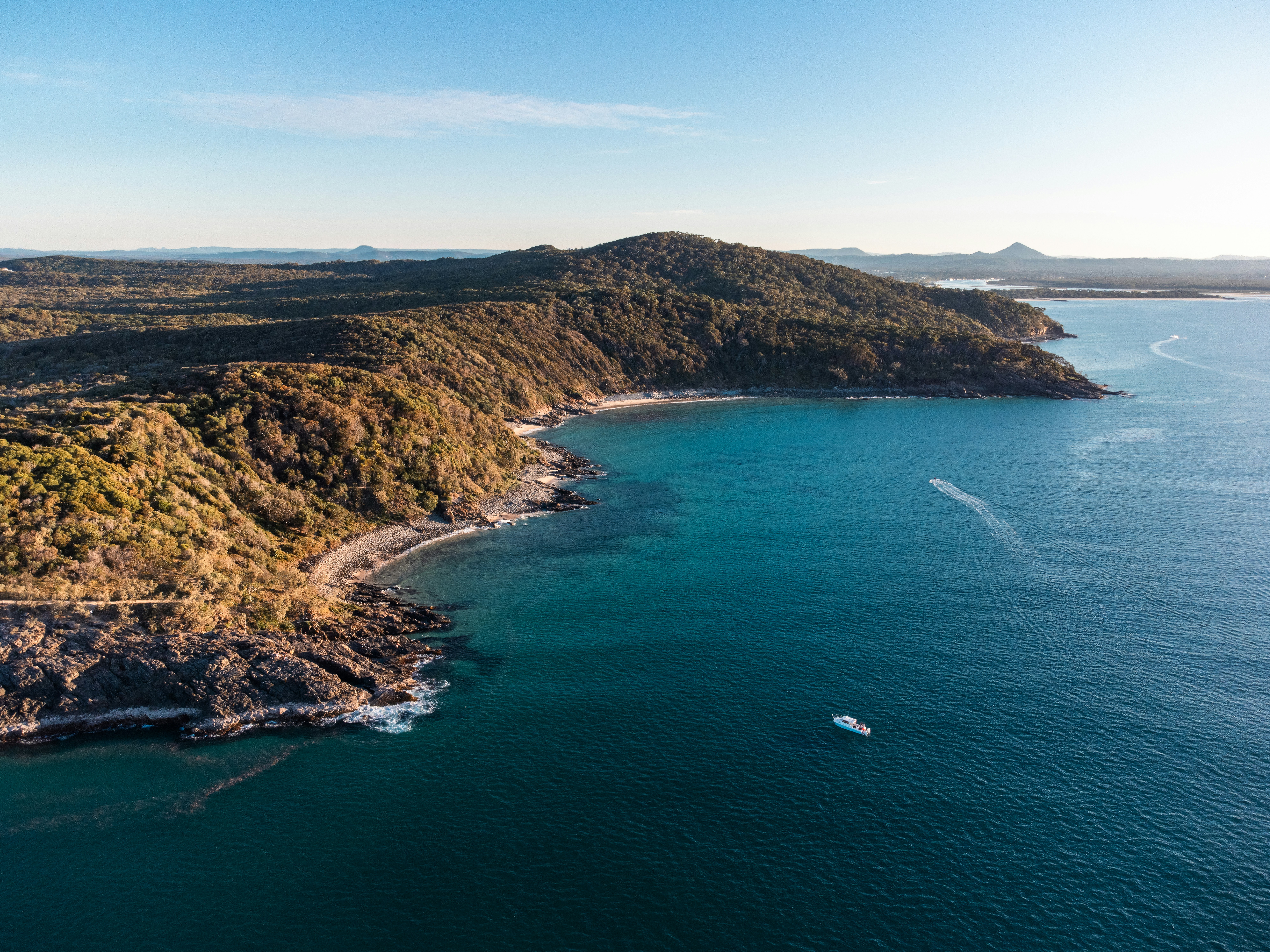 an aerial view of an island with a boat in the water