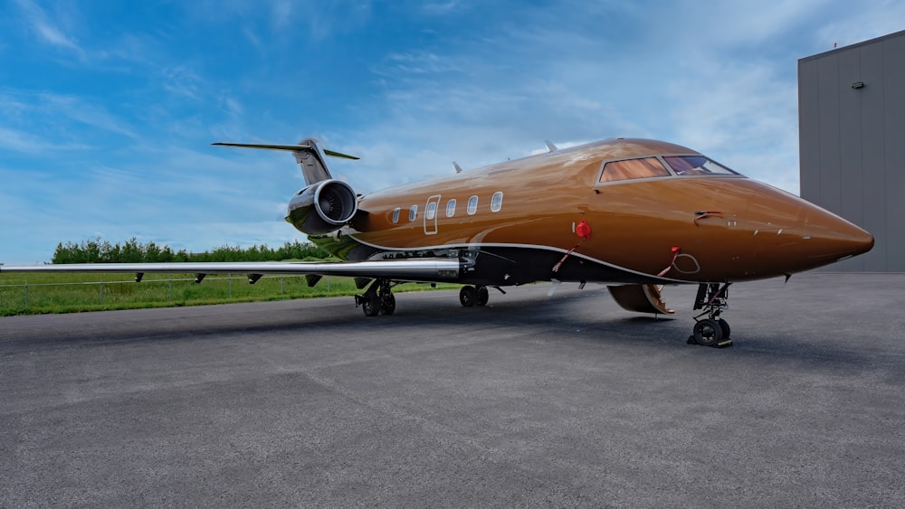 a brown airplane sitting on top of an airport tarmac