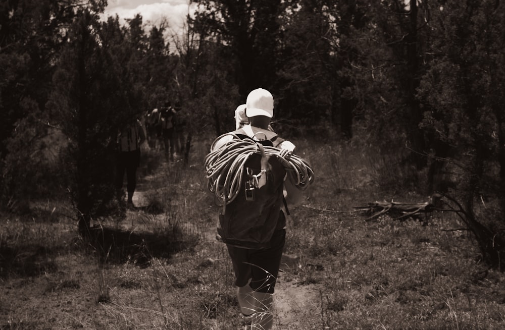 a black and white photo of a person walking in the woods