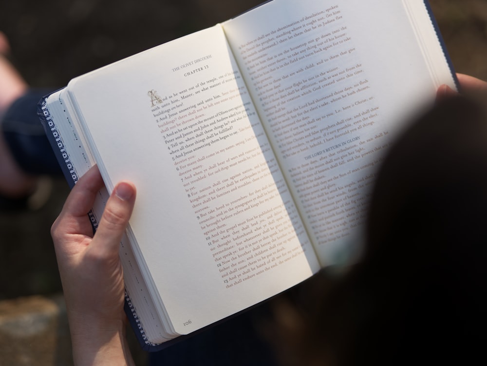 uma pessoa segurando um livro nas mãos