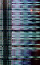 A close-up view of a digital display showing a grid pattern composed of tiny illuminated pixels. The arrangement includes vertical and horizontal lines forming a matrix with repeated patterns of light in vibrant colors.