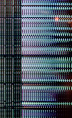 A close-up view of a digital display showing a grid pattern composed of tiny illuminated pixels. The arrangement includes vertical and horizontal lines forming a matrix with repeated patterns of light in vibrant colors.