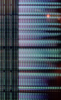 A close-up view of a digital display showing a grid pattern composed of tiny illuminated pixels. The arrangement includes vertical and horizontal lines forming a matrix with repeated patterns of light in vibrant colors.