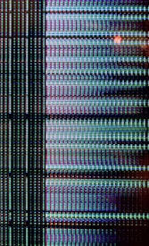 A close-up view of a digital display showing a grid pattern composed of tiny illuminated pixels. The arrangement includes vertical and horizontal lines forming a matrix with repeated patterns of light in vibrant colors.