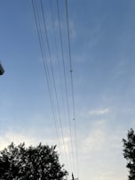 A high-voltage power line stretching across a clear blue sky.