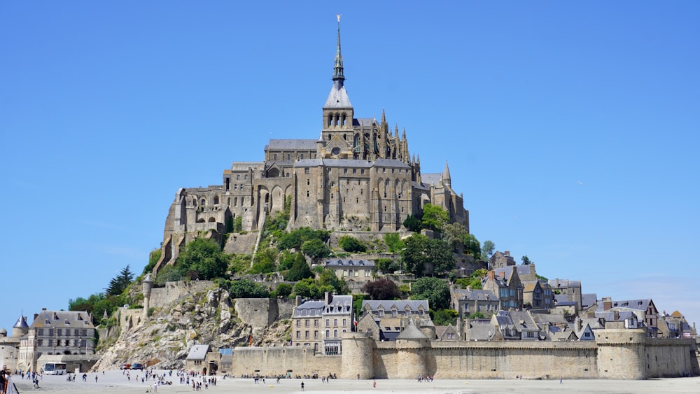 a castle on top of a hill with people walking around it