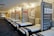 A showroom with multiple rows of neatly arranged bed frames and mattresses. The beds are all aligned in a clean, spacious environment with a modern design. The walls display various bed-related equipment and informational posters.