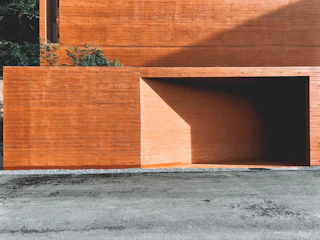 A sturdy compound wall surrounding a commercial property, featuring smooth precast concrete panels with subtle orange accent lighting.
