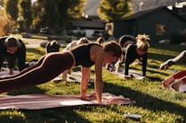 a group of people doing yoga in the grass