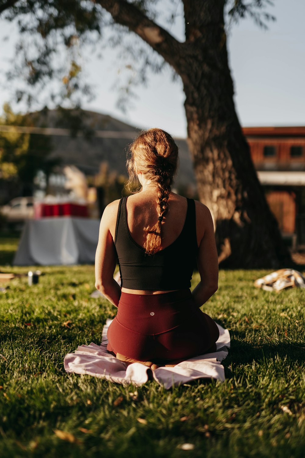 a woman sitting in a yoga position in the grass