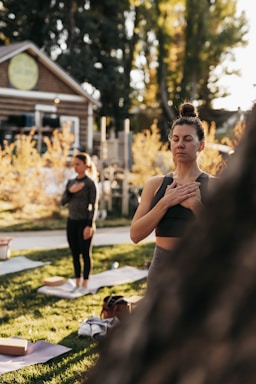 A serene portrait of the founder leading a calming yoga session outdoors at sunrise.