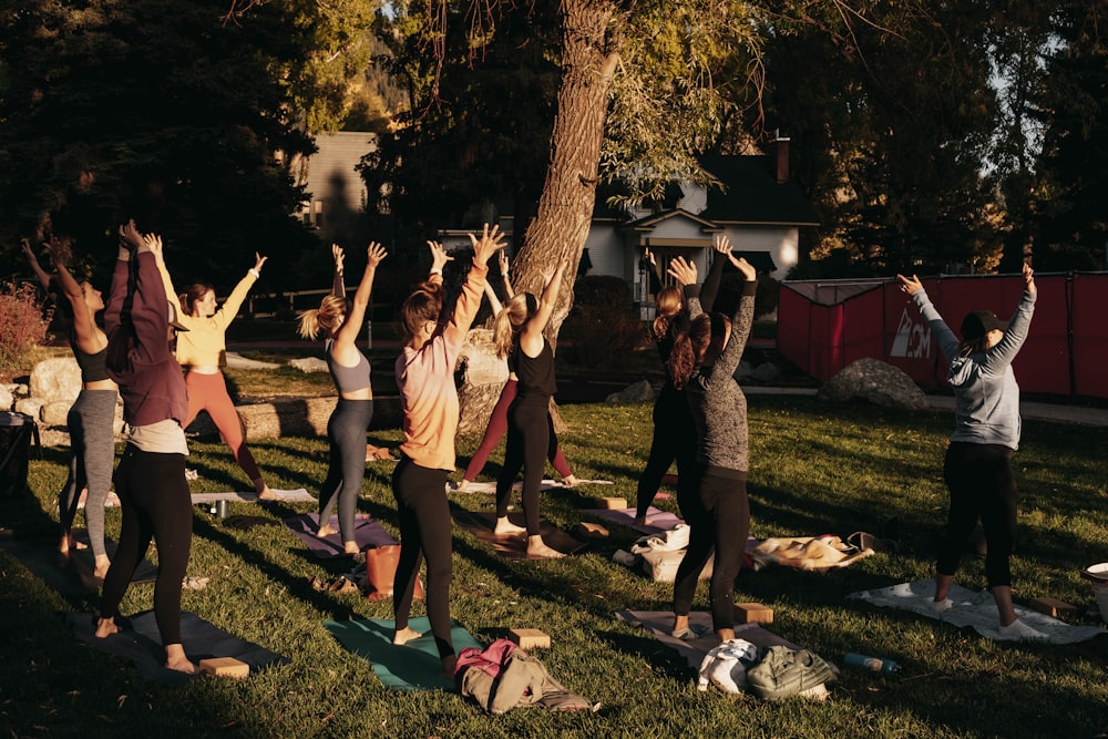 a group of people doing yoga in a park