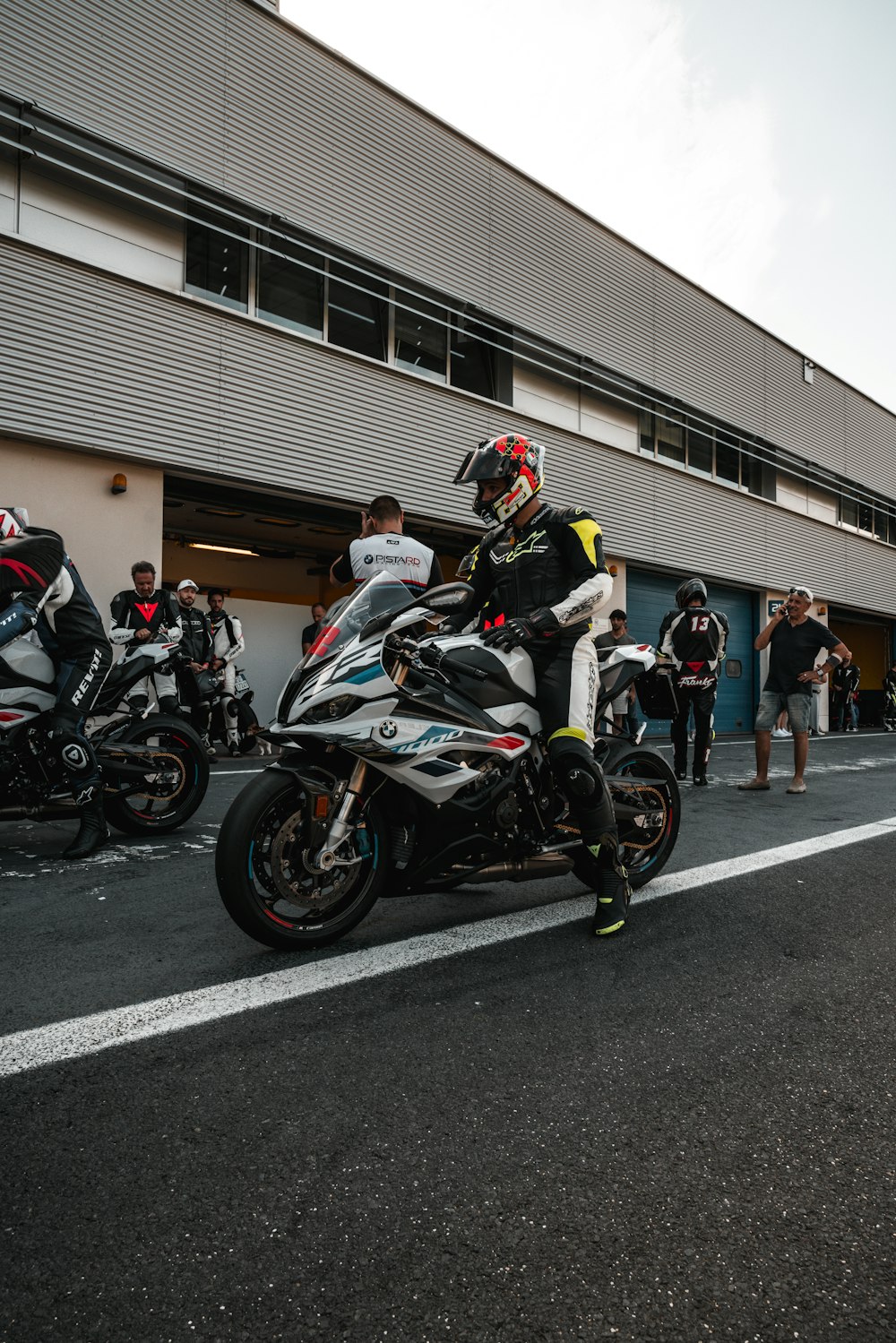 a man riding a motorcycle down a street next to other motorcycles