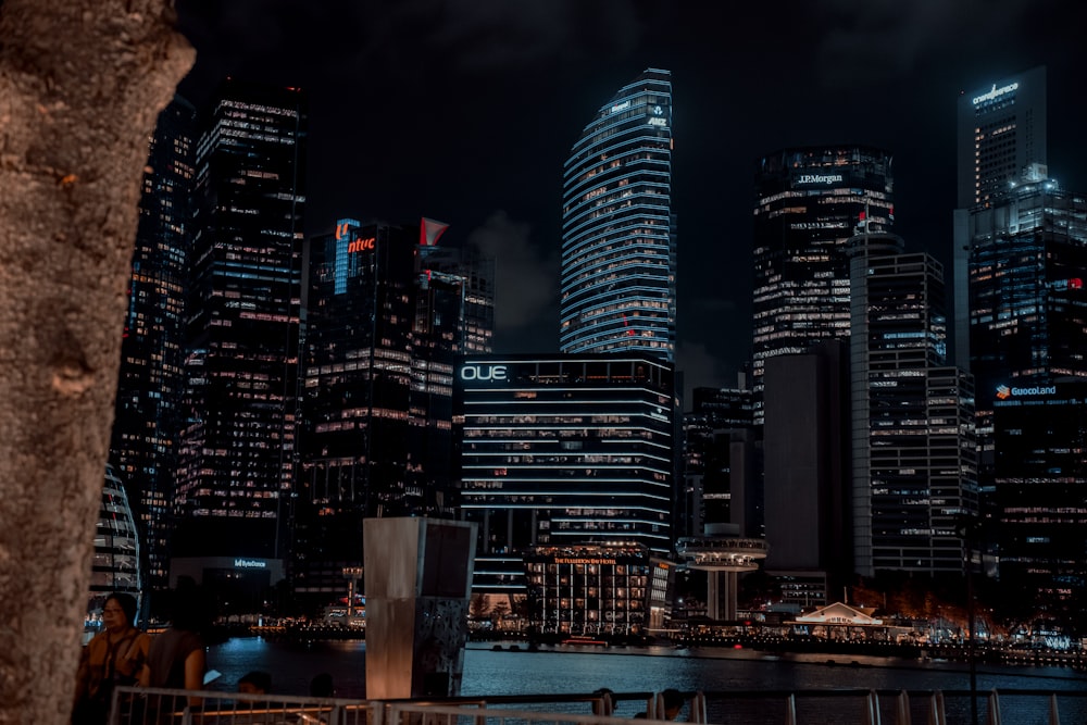 a city skyline at night with tall buildings
