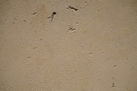 Close-up of thick insulation material being applied inside a wall