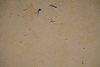 Close-up of a handyman patching a drywall hole with joint compound.