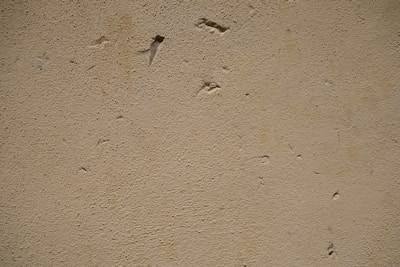 Close-up of a handyman patching a drywall hole with joint compound.