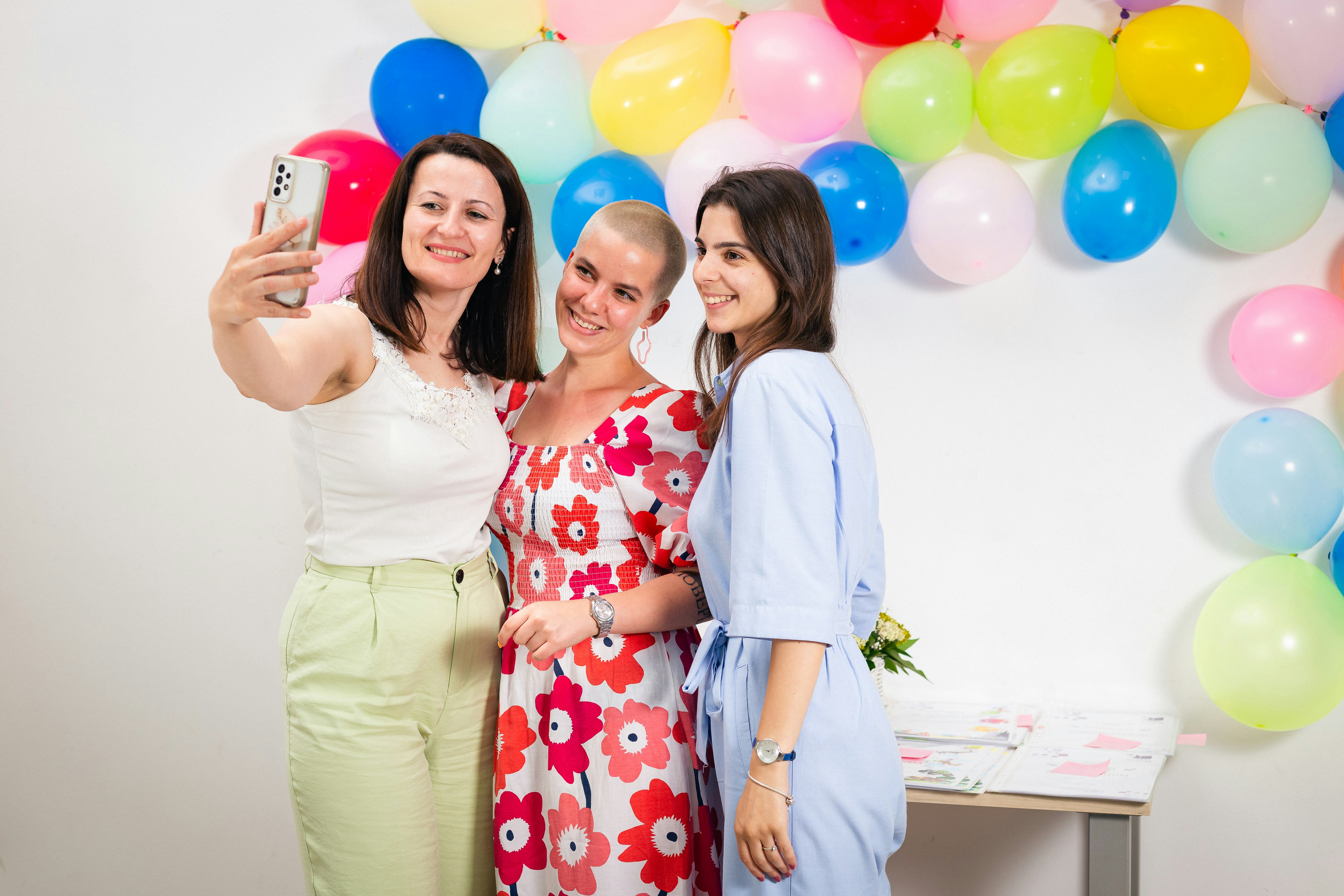three women taking a picture with a cell phone