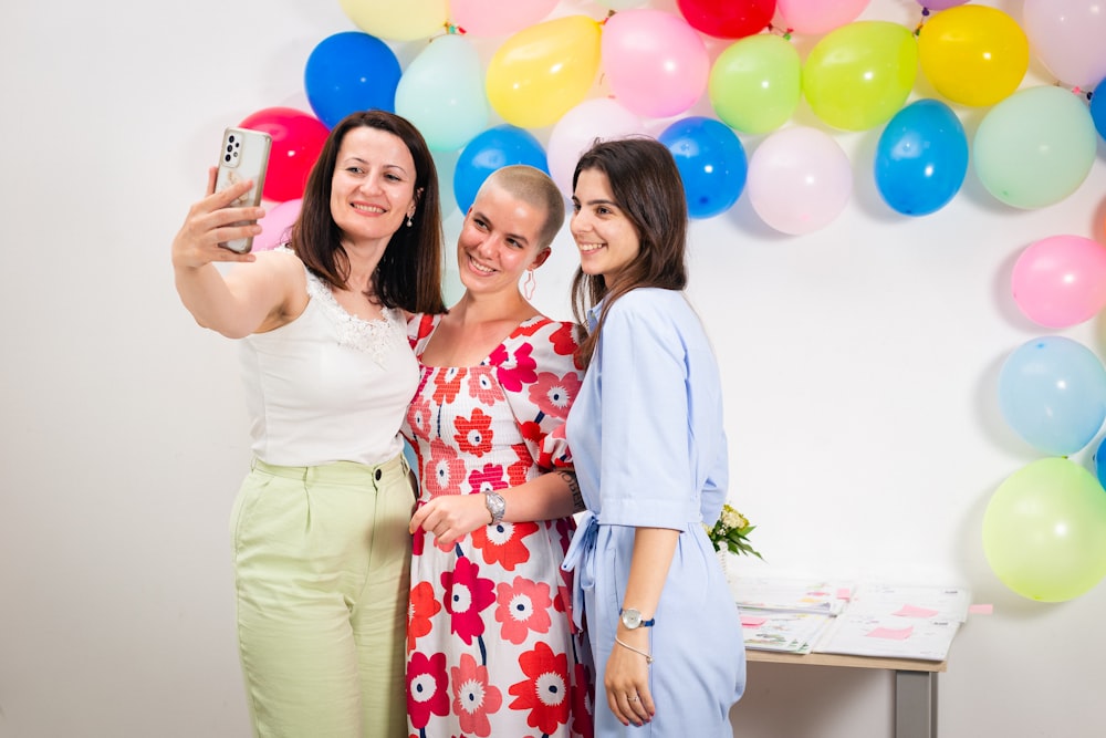 three women taking a picture with a cell phone