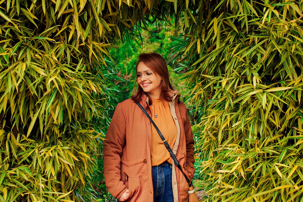 a woman standing in front of a bamboo tree