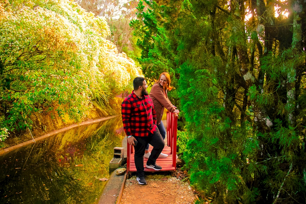 a man and a woman standing on a bridge over a river