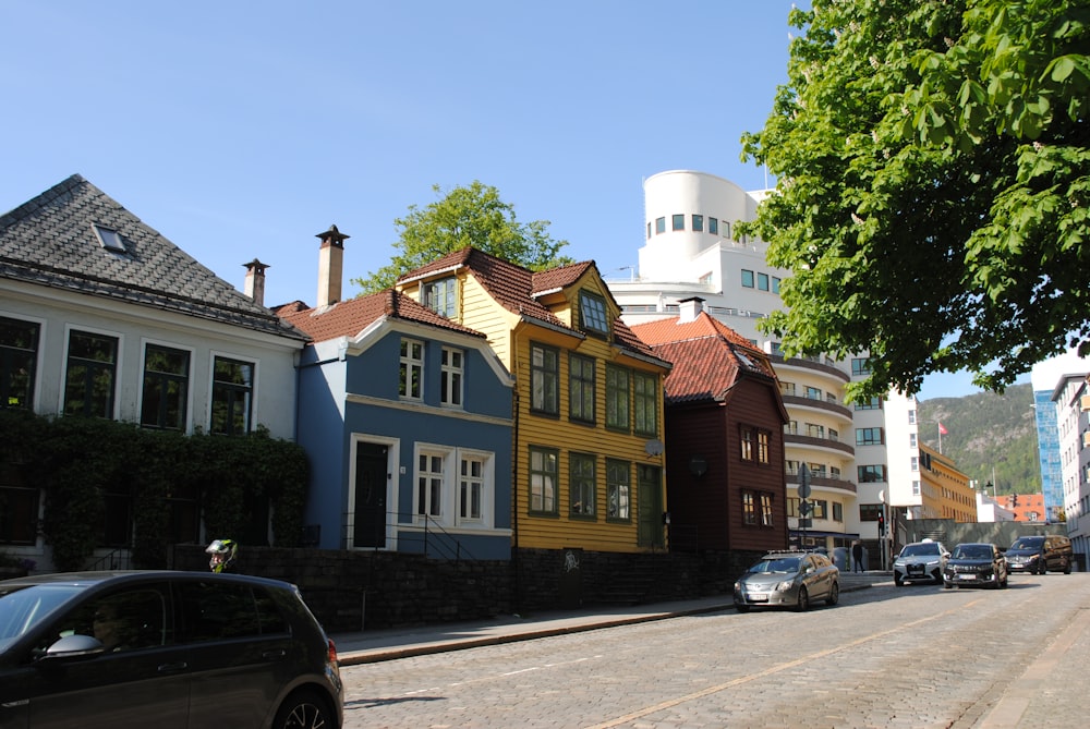 a row of colorful houses line a street in a small town