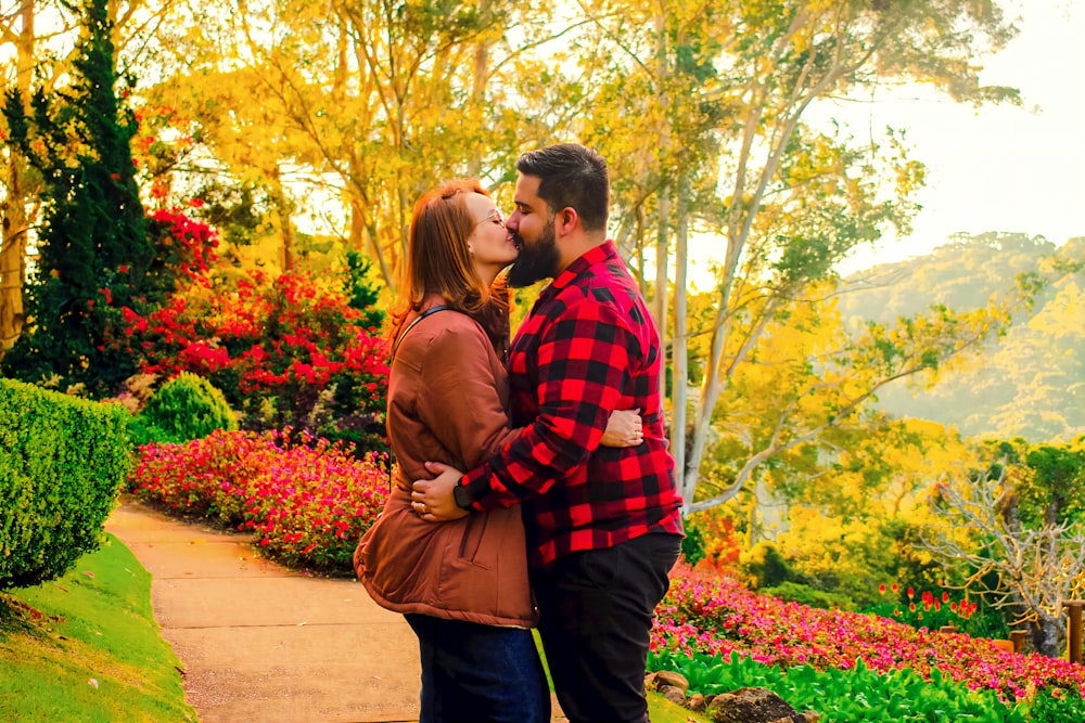 Un uomo e una donna che si baciano in un giardino