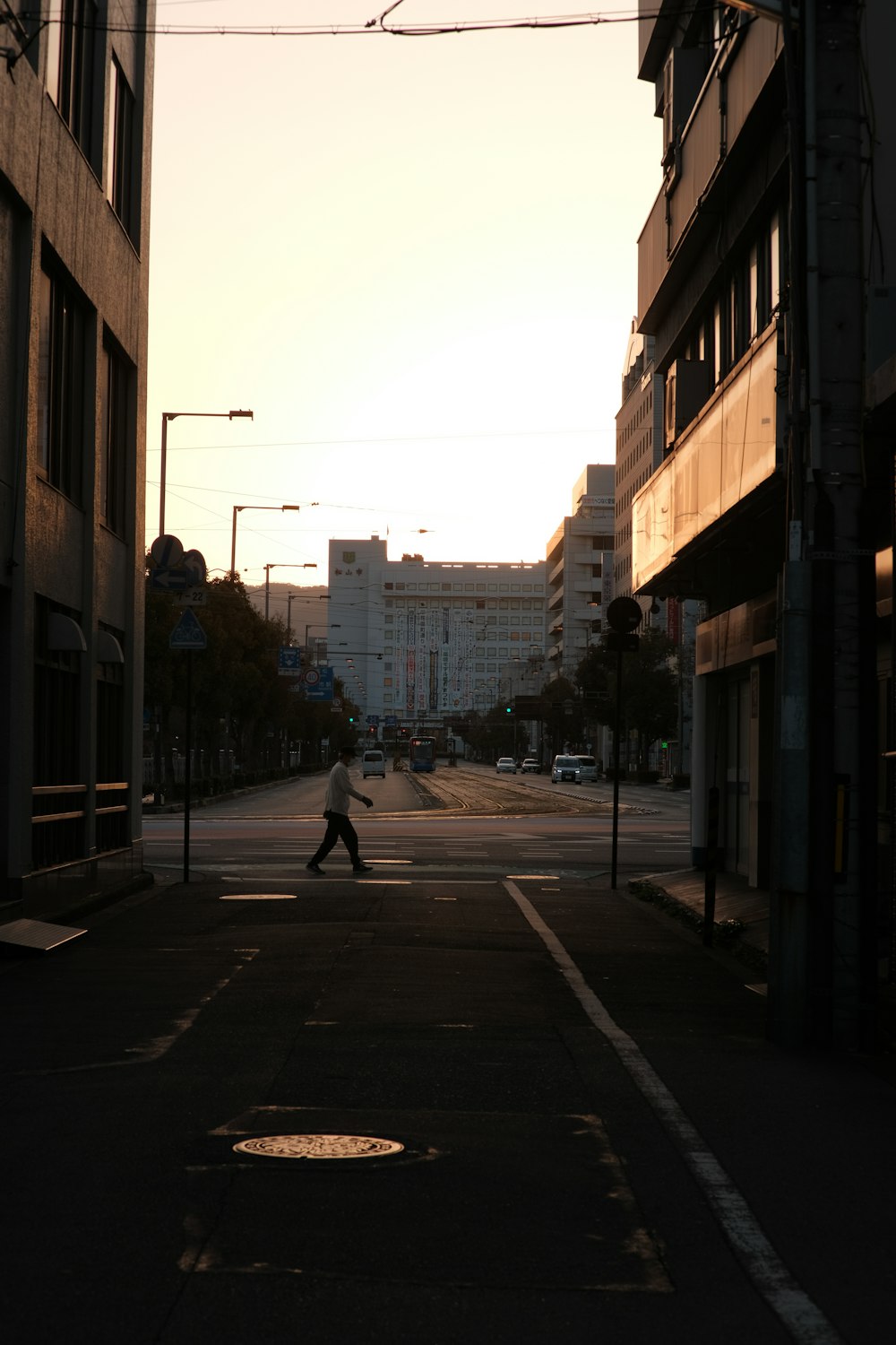 a person walking down a street at sunset