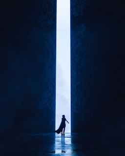 An intricate depiction of a doorway opening into a realm of shifting shadows and glowing symbols, inviting curiosity.