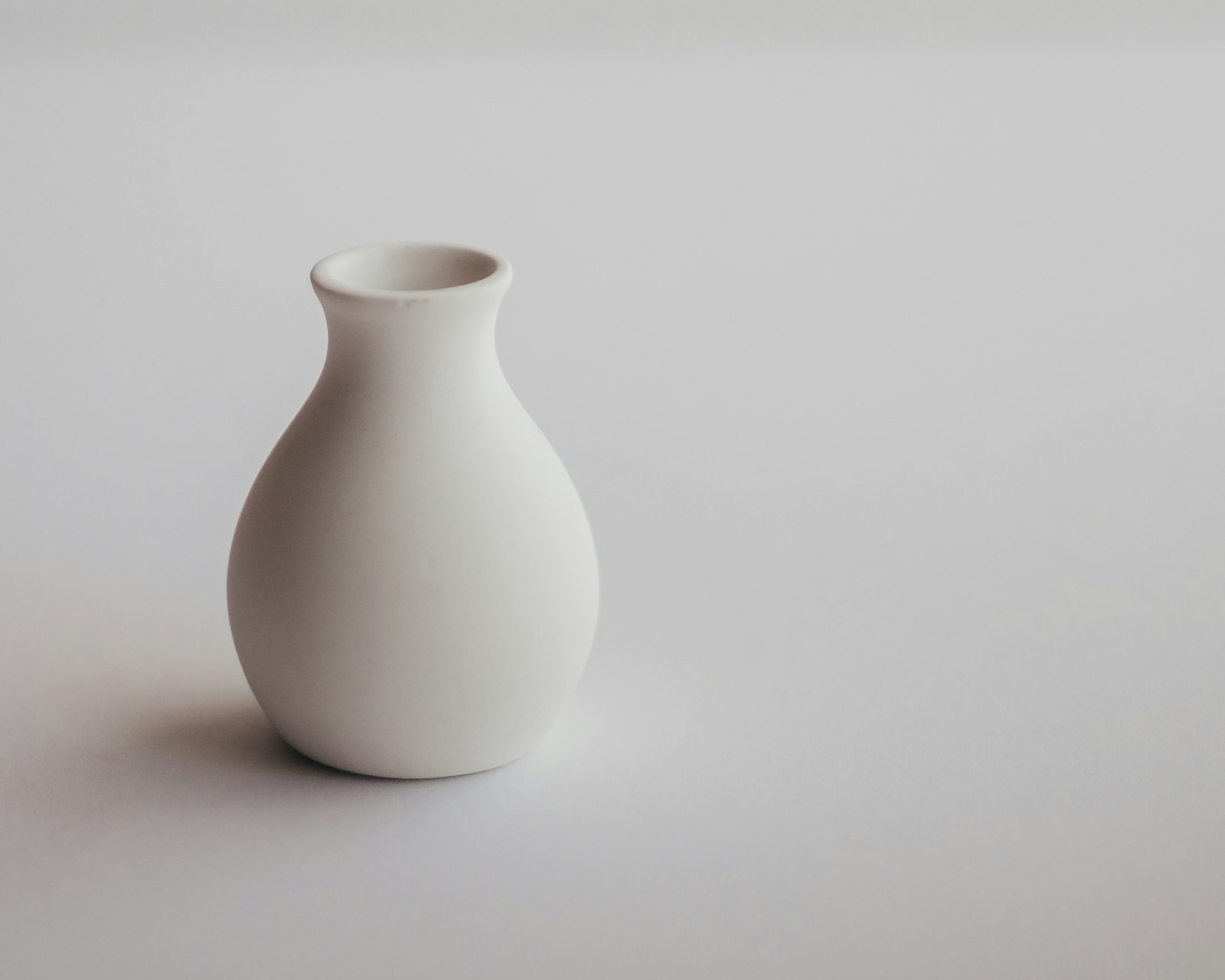 A white ceramic vase on a white table