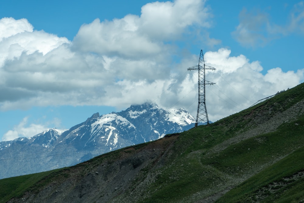 a telephone pole on a hill with a mountain in the background