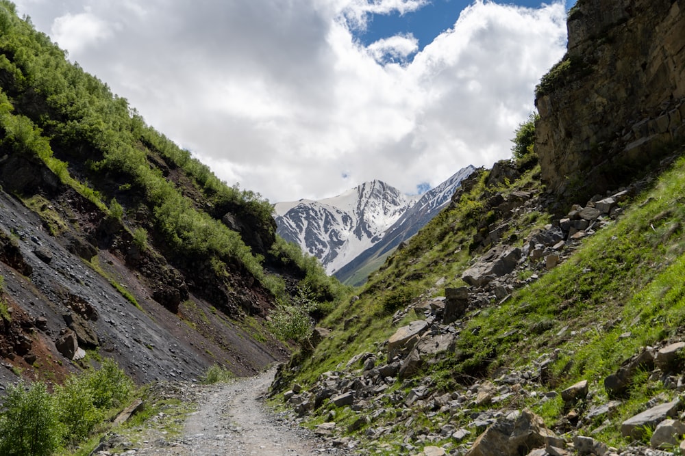 a dirt road with a mountain in the background