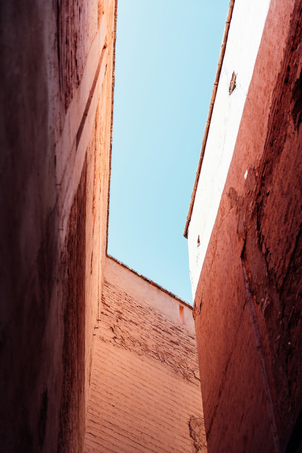 a narrow alley way with a blue sky in the background