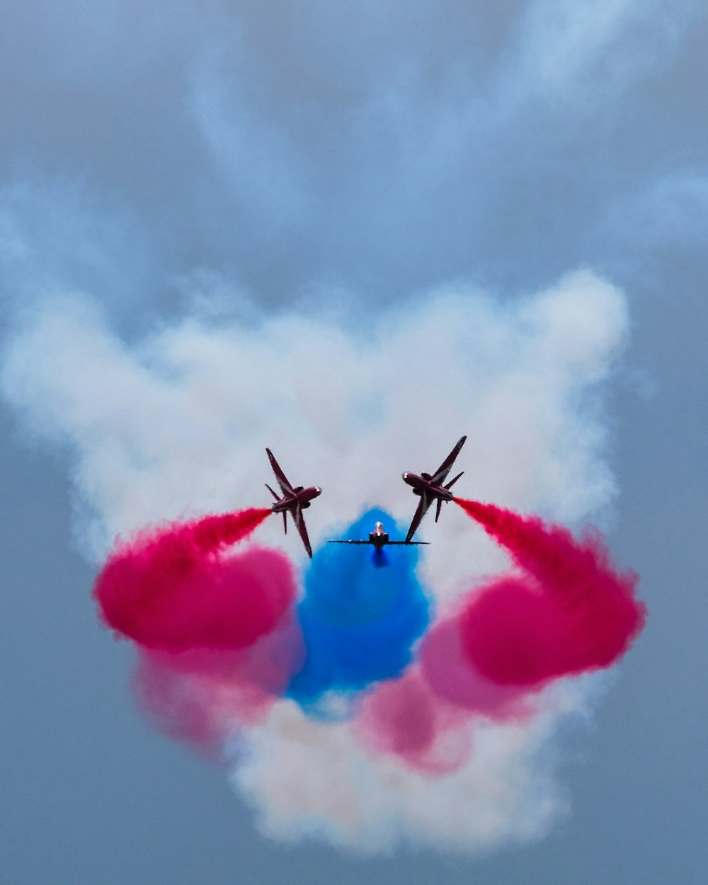 a couple of airplanes flying through a cloudy sky