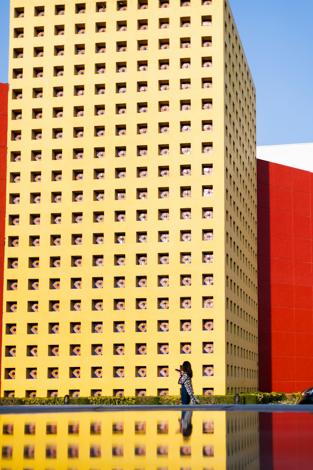 a tall yellow building next to a body of water