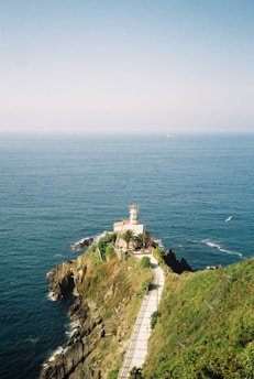 a lighthouse on a cliff overlooking the ocean