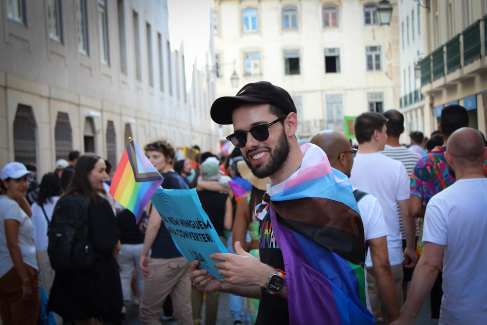 a man wearing a rainbow cape and holding a book