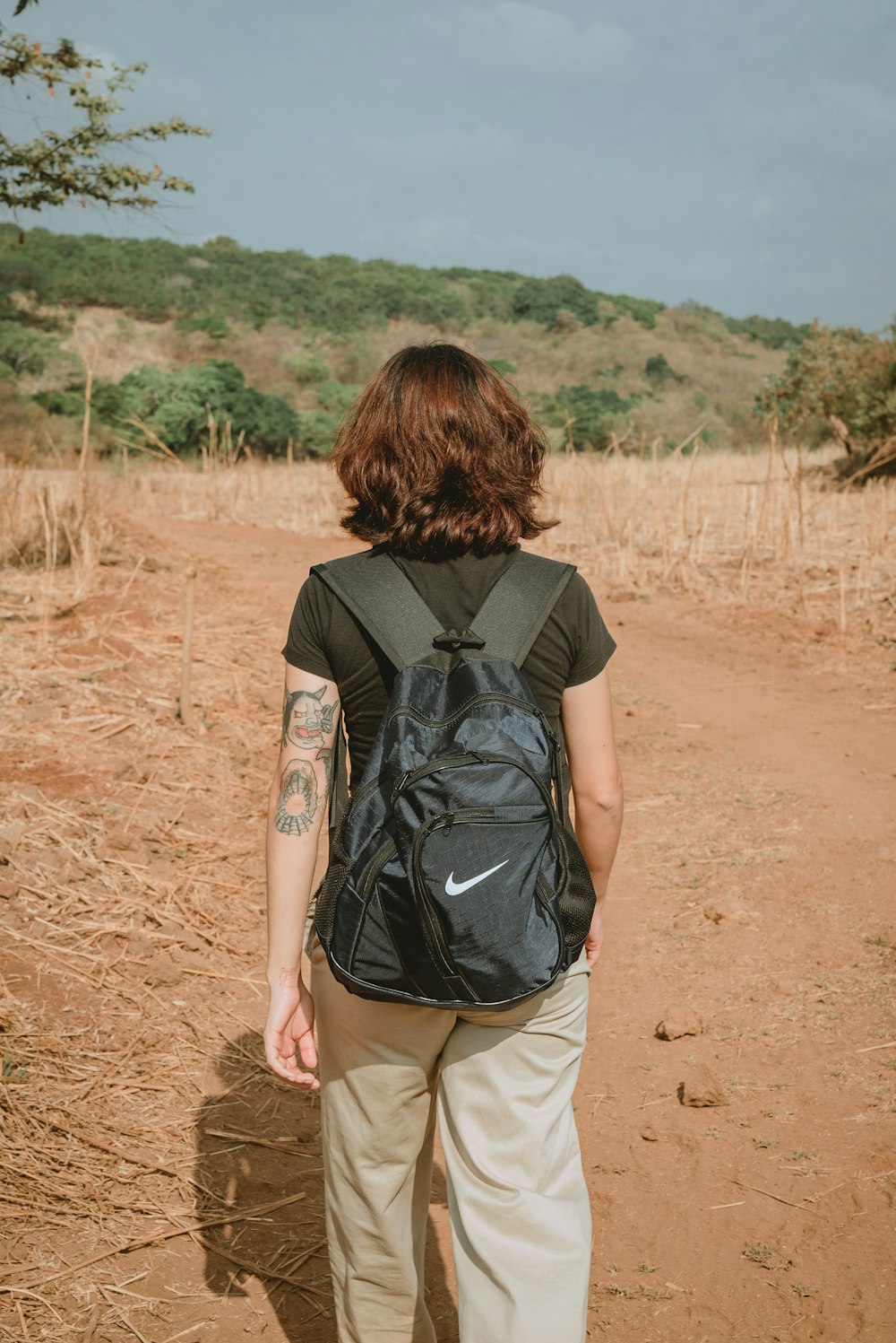 a person with a backpack walking on a dirt road