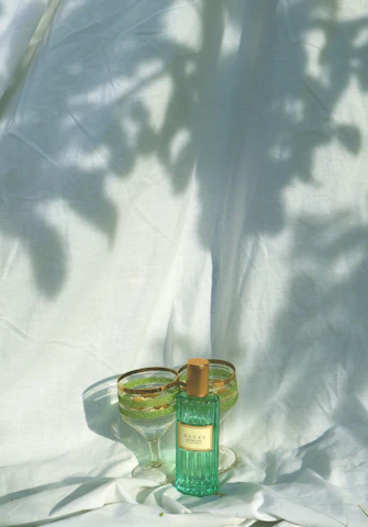 Elegant dark green and gold perfume decant bottles arranged on a black velvet surface with soft lighting.