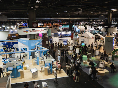 A vibrant trade exhibition hall bustling with African entrepreneurs engaging with international visitors.