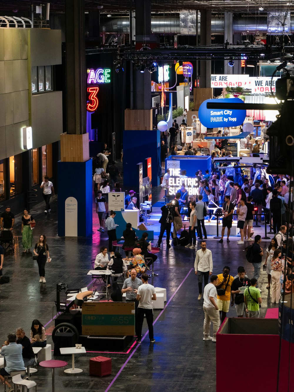 a crowd of people standing around a convention hall