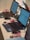 Several laptops with screens displaying a programming interface are arranged on a table. Pink USB cables and mice are connected to the laptops. Small electronic components are also present near the laptops.