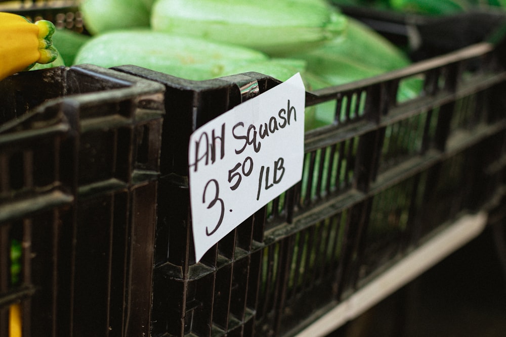 a black basket filled with cucumbers and other produce