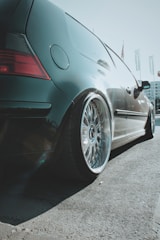 Sleek car with custom alloy wheels parked on a city street.