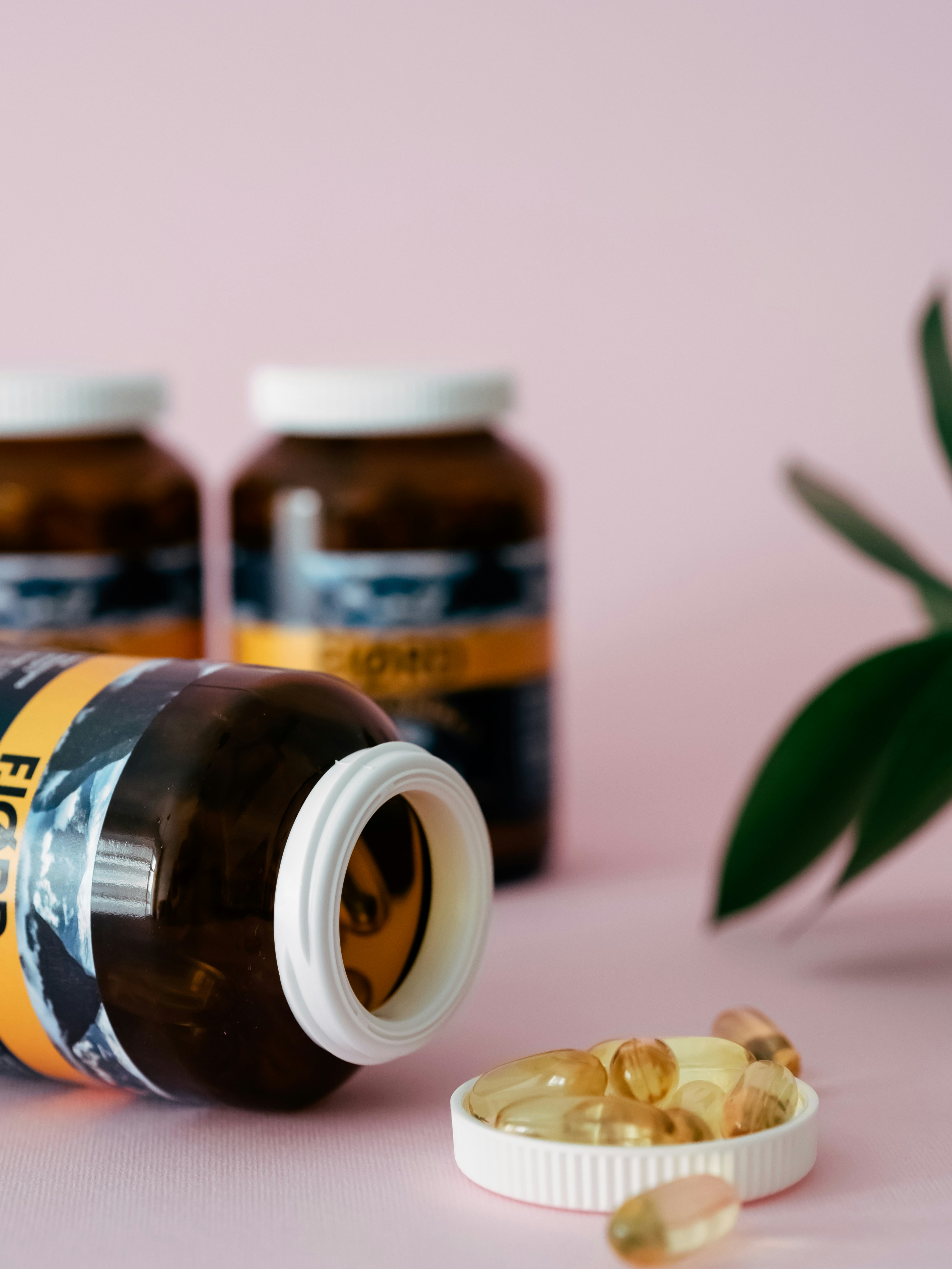 Un primer plano de un frasco de pastillas junto a una planta